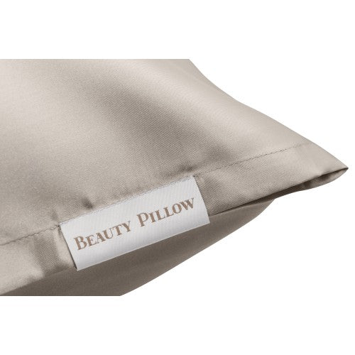Close-up van de Beauty Pillow Sandy Beach satijnen kussensloop met het label in beeld, ideaal voor een rustgevende schoonheidsslaap.